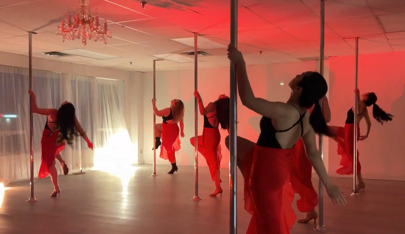 Body Evolution Studios dancers performing a group pole routine